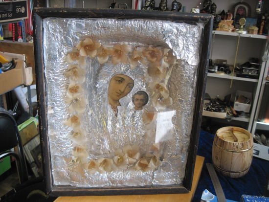 Икона Богоматери в деревянном окладе под стеклом.