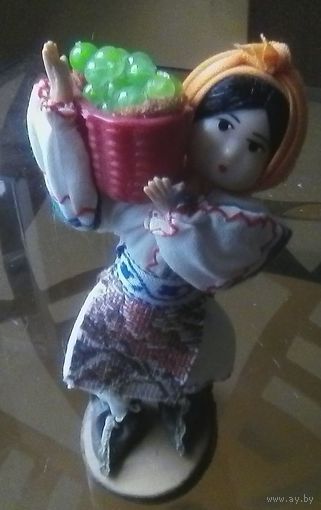 Кукла в национальном костюме с корзиной винограда